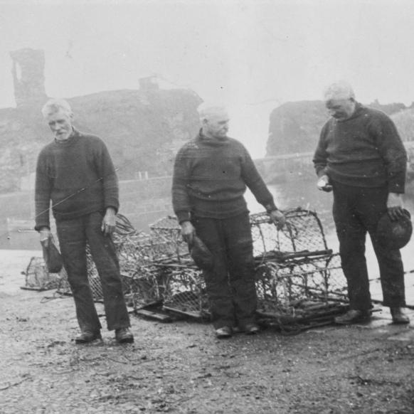 Three fisherman taking part in a two minute silence on Armistice Day, Victoria harbour, Dunbar. L-R: Unknown, unknown, John 'Gallagher' Johnstone. Johnstone was the Skipper of then 3.15 ton 'Isa', LH202. Alex Johnston was the owner. Original - C. Carruthers.