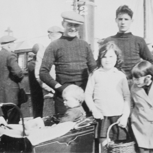 Group of people on Anstruther pier, 1932. Back row, L-R: Phemie Corstorphine, David Corstorphine, David Corstorphine, John Ballingall, Front row, L-R; Sonny Corstorphine (in pram), Unknown Ballingall, Jessie Corstorphine.