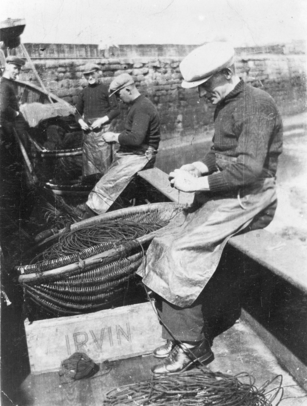 Baiting lines onboard 'Fifeness'. L-R: A. Tawse, P. Doig, A. Watson, and A. Smith. Her Skipper was W. Sutherland. Irvin's were fish buyers based near Edinburgh. Original image from Mrs Johnson Smith.
