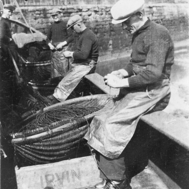 Baiting lines onboard 'Fifeness'. L-R: A. Tawse, P. Doig, A. Watson, and A. Smith. Her Skipper was W. Sutherland. Irvin's were fish buyers based near Edinburgh. Original image from Mrs Johnson Smith.